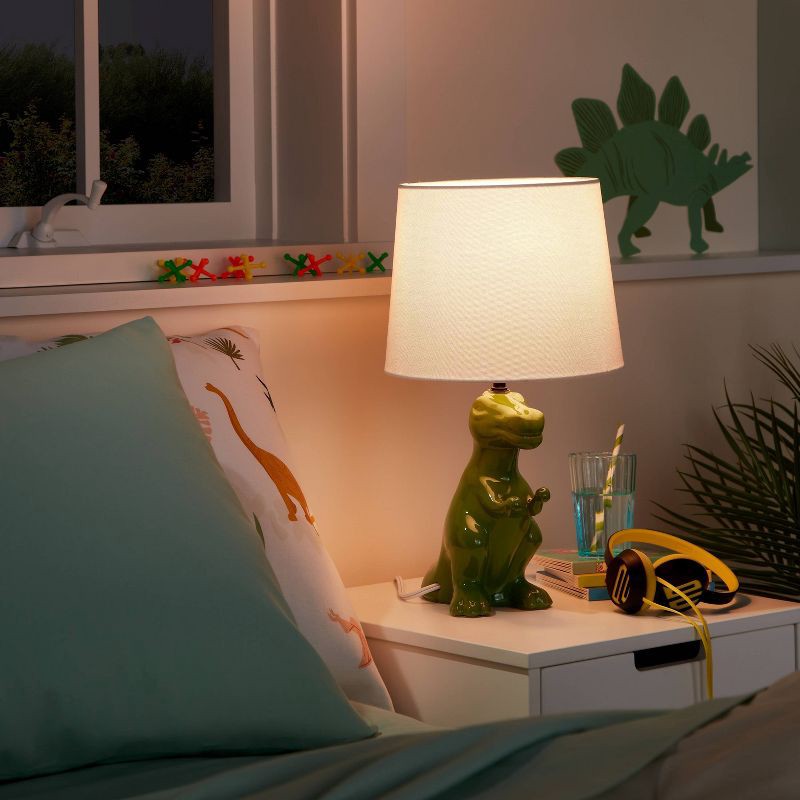 slide 1 of 5, Dinosaur Kids' Table Lamp (Light Bulbs Not Included) Green - Pillowfort™: Dino Lights for Boys, Ceramic Accent Lamp, 1 ct