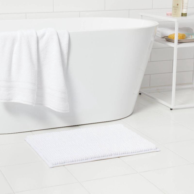 slide 2 of 4, 17"x24" Chunky Chenille Cushion Foam Bath Rug White - Room Essentials™, 1 ct