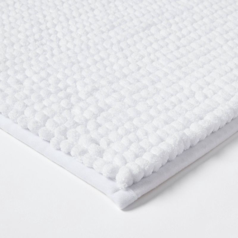 slide 3 of 4, 17"x24" Chunky Chenille Cushion Foam Bath Rug White - Room Essentials™, 1 ct