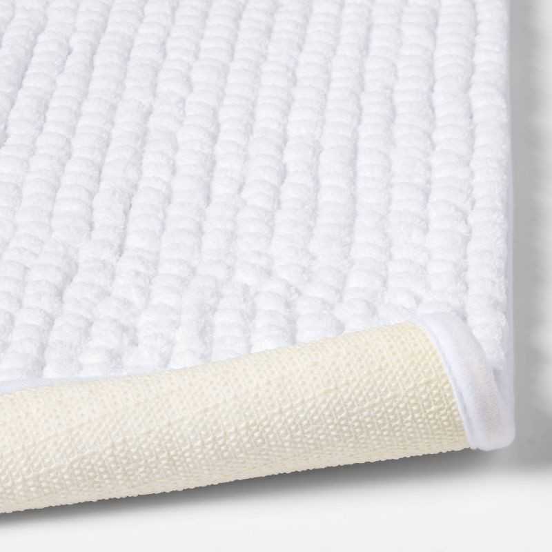 slide 4 of 4, 17"x24" Chunky Chenille Cushion Foam Bath Rug White - Room Essentials™, 1 ct
