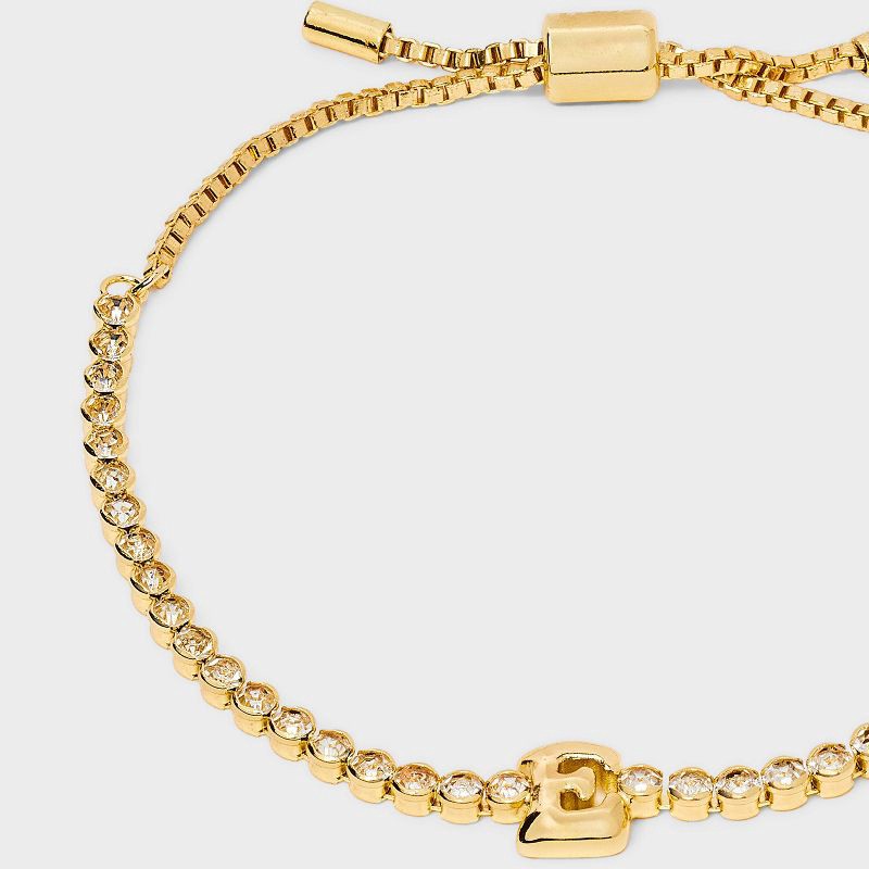 slide 4 of 4, SUGARFIX by BaubleBar Crystal Initial "E" Chain Bracelet - Gold: Brass Stretch Jewelry, Drawstring Closure, 8" Length, 1 ct