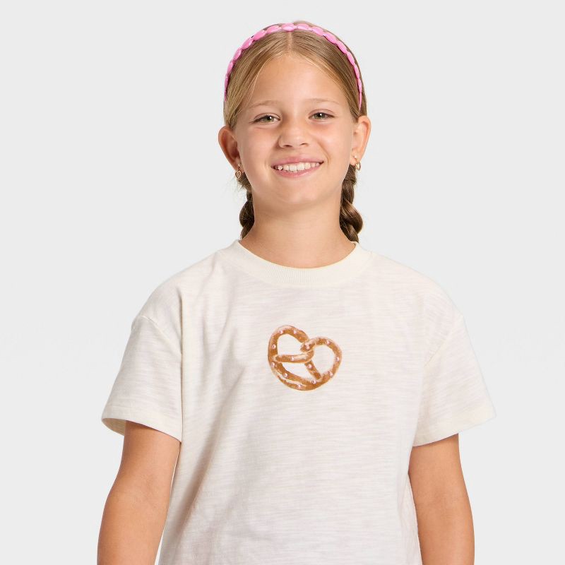 slide 2 of 4, Girls' Short Sleeve Pretzel Relaxed Fit Graphic T-Shirt - Cat & Jack™ Cream XL, 1 ct